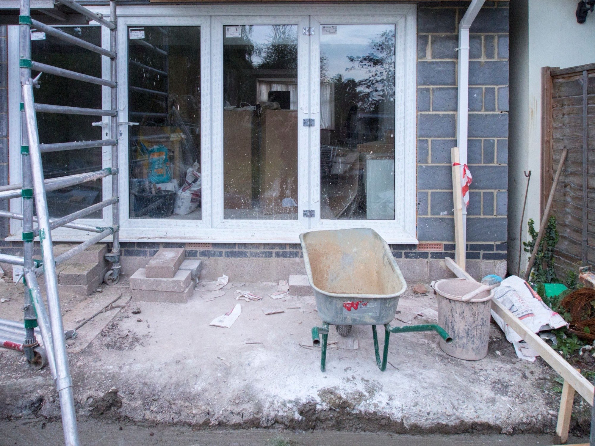 A property mid-build with scaffolding up and the new windows in — the middle stage of a typical job